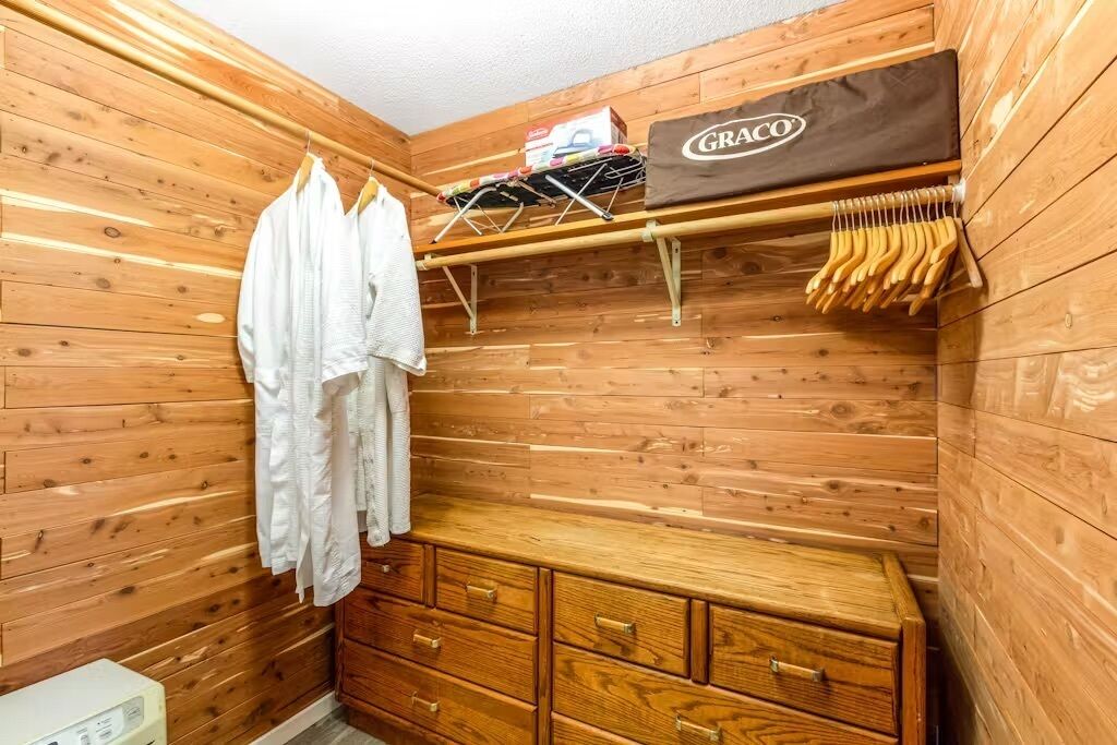 Eine Holzhütte mit einer Holzbank, einem Wäscheständer und einer Tasche der Marke Graco.