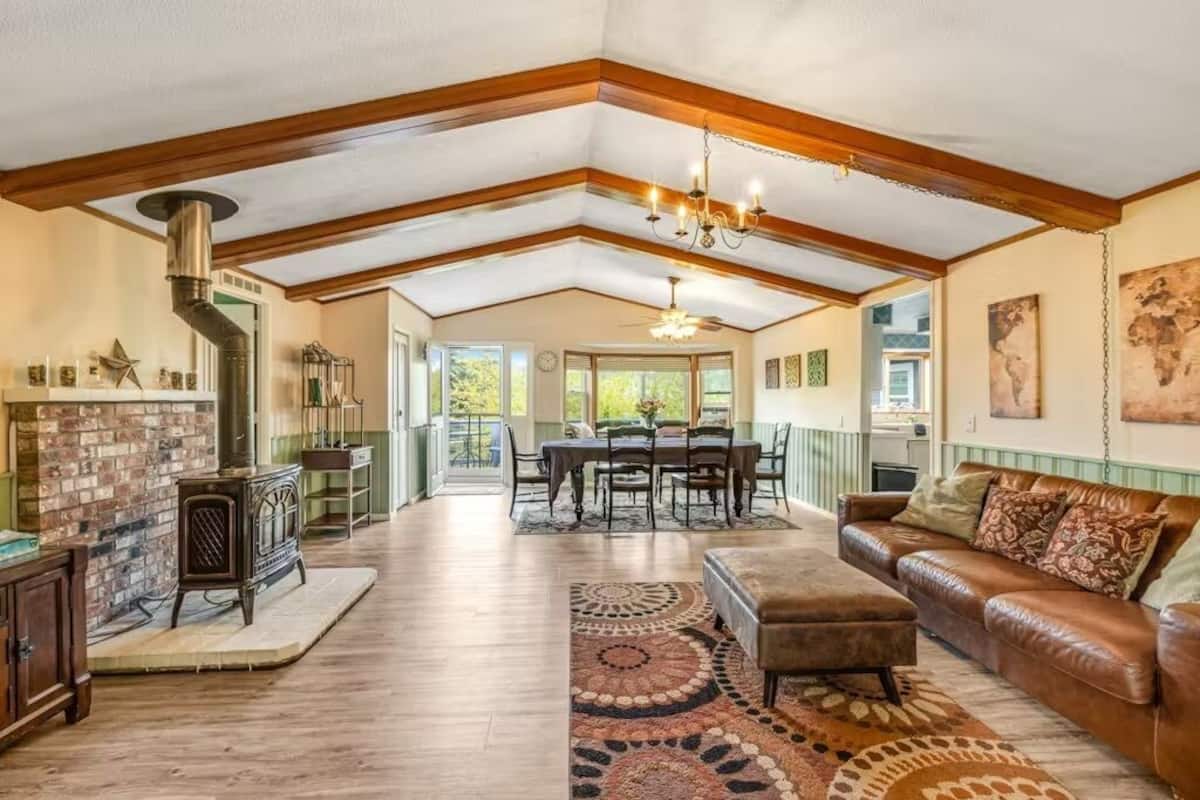 A spacious living room with a fireplace, a dining area, and a large window providing natural light.