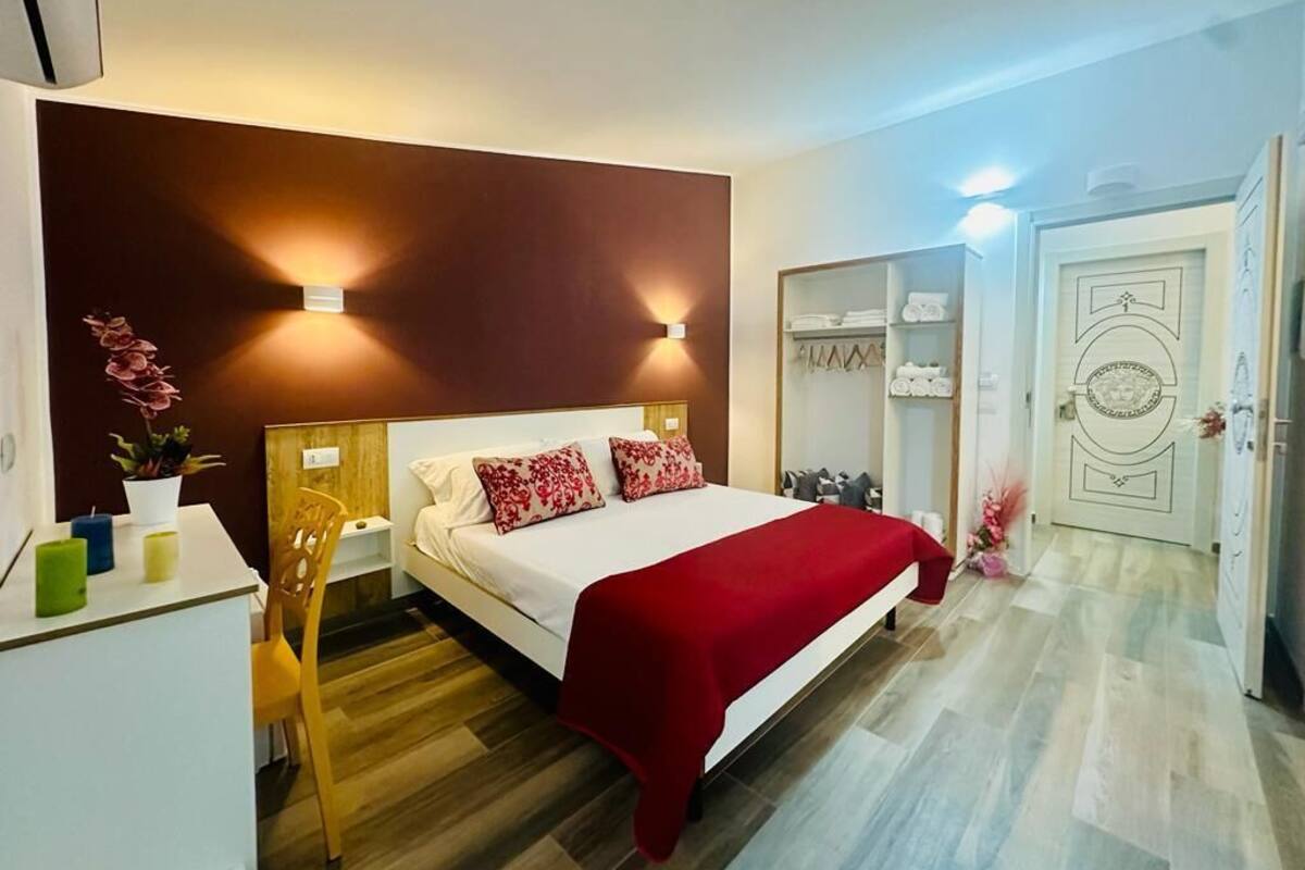 Un dormitorio con cama, mesitas de noche, armario y espejo.