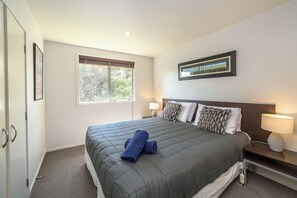 A hotel room with a bed, two bedside lamps, a window, and a framed picture on the wall. - Apartment Sauvignon, Martinborough (Martinborough)