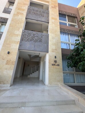 A multi-story building with a modern design, featuring a central staircase leading to an upper floor.