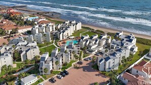 A coastal hotel with multiple buildings, a beach, and a pier. - Amazing Panoramic Ocean Paradise (South Padre Island)