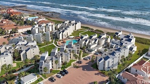 A coastal residential area with modern buildings, a swimming pool, and a beach. - Solare Tower Sunset Panorama Paradise (South Padre Island)