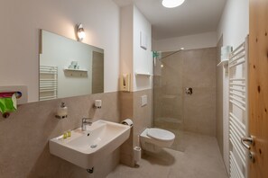A modern bathroom with a sink, toilet, and shower.