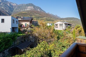 Un barrio residencial con casas modernas, un muro de piedra y una montaña al fondo.