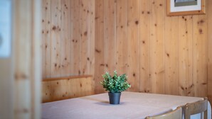 Una stanza con pareti in legno, una piccola pianta in vaso su un tavolo e un quadro appeso al muro.