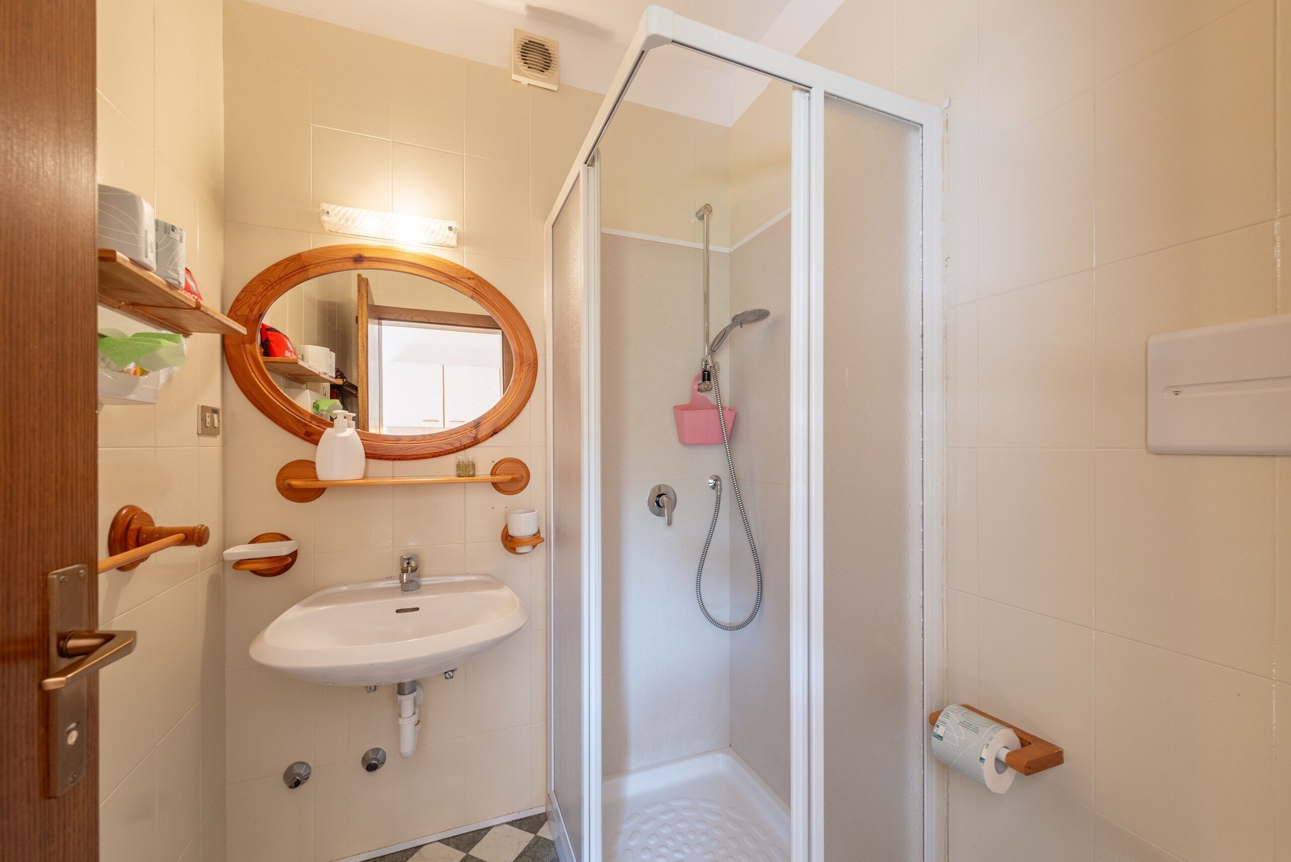Ein Badezimmer mit Dusche, Waschbecken und Spiegel.