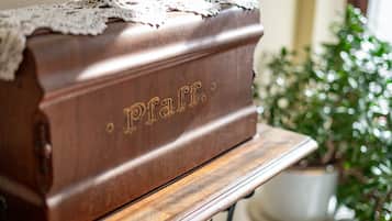 Une boîte en bois portant l’inscription « Pfaff », gravée sur le dessus, posée sur une table en bois.