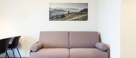 Ein modernes Wohnzimmer mit einer Couch, einem Esstisch und Stühlen.
