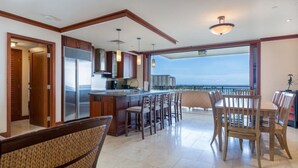 A spacious kitchen with a large island, wooden cabinets, and a view of the ocean. - 3br + 2br on the Same Floor - Sleeps 13! Amazing for Families (Kapolei)