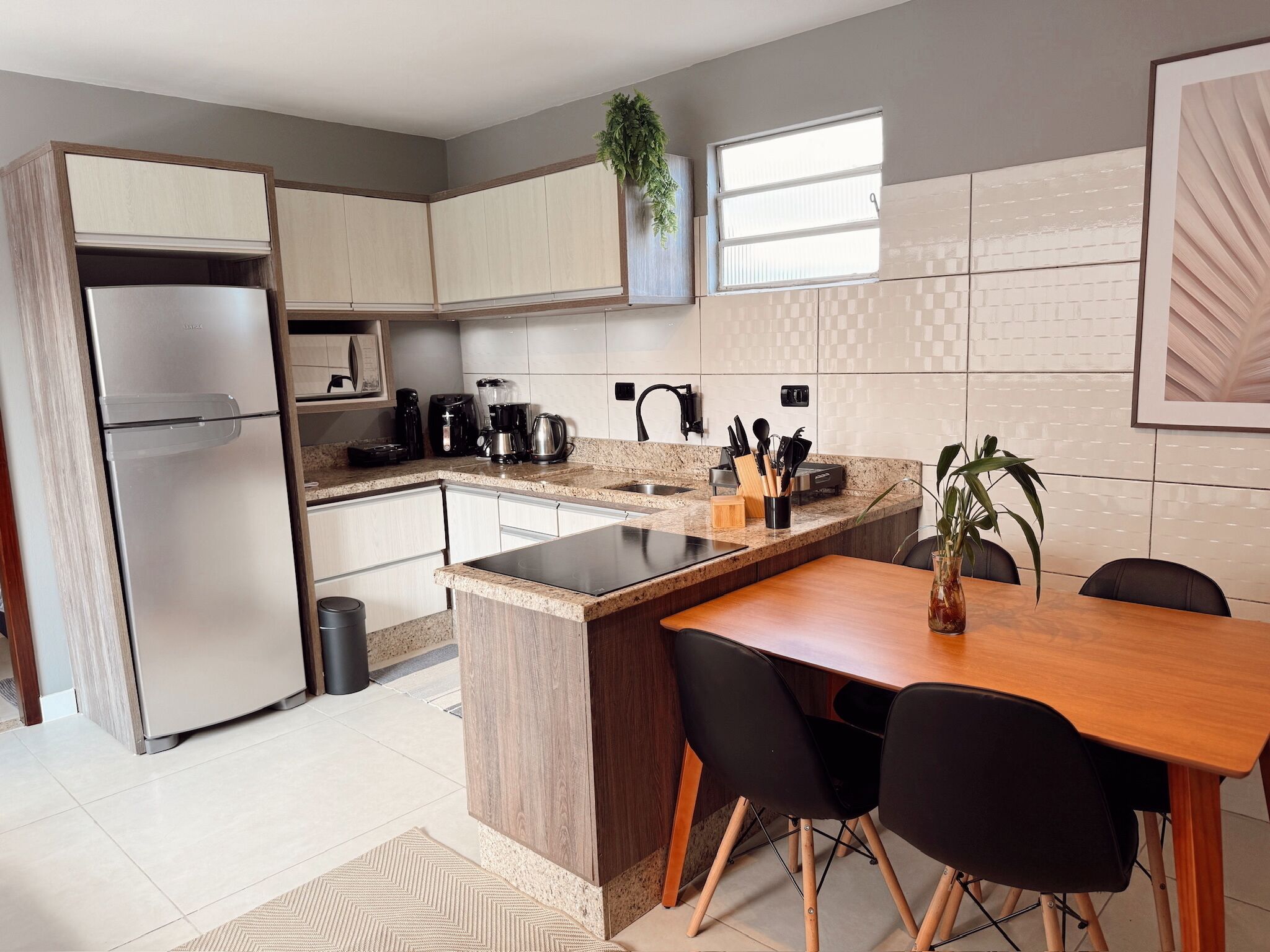 A modern kitchen with a built-in refrigerator, a coffee maker, and a sink.