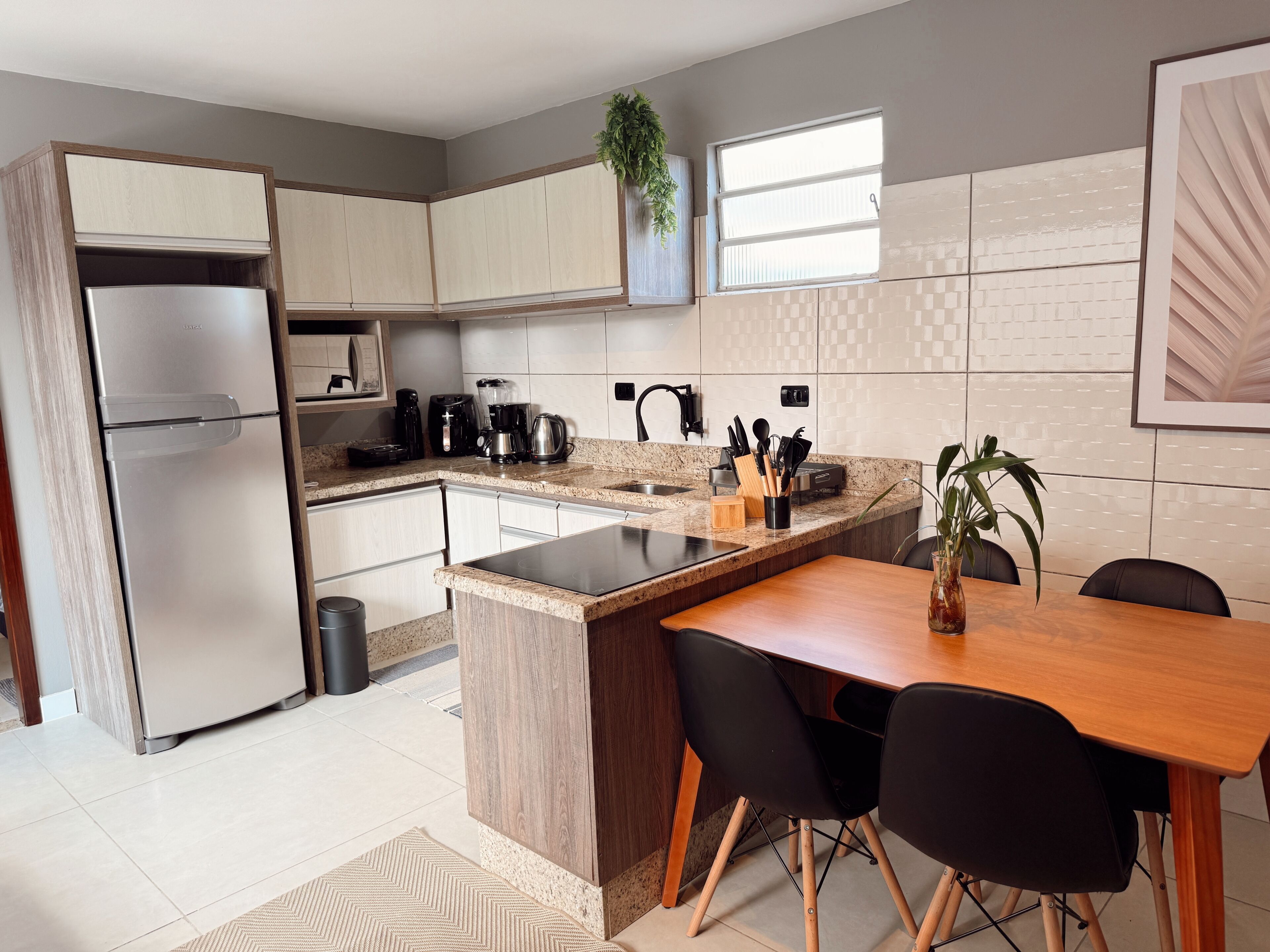 A modern kitchen with a built-in refrigerator, a coffee maker, and a sink.