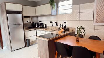 A modern kitchen with a built-in refrigerator, a coffee maker, and a sink.