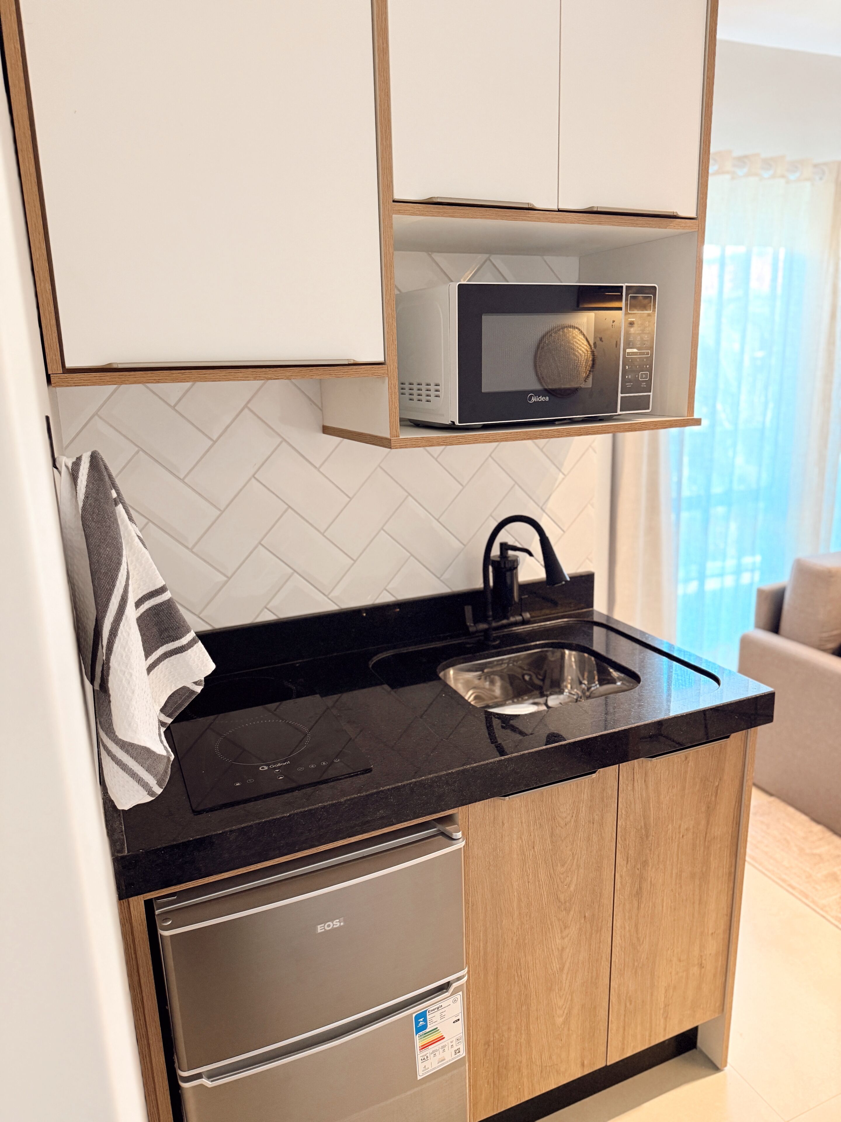 A compact kitchen with a microwave, sink, and dishwasher.