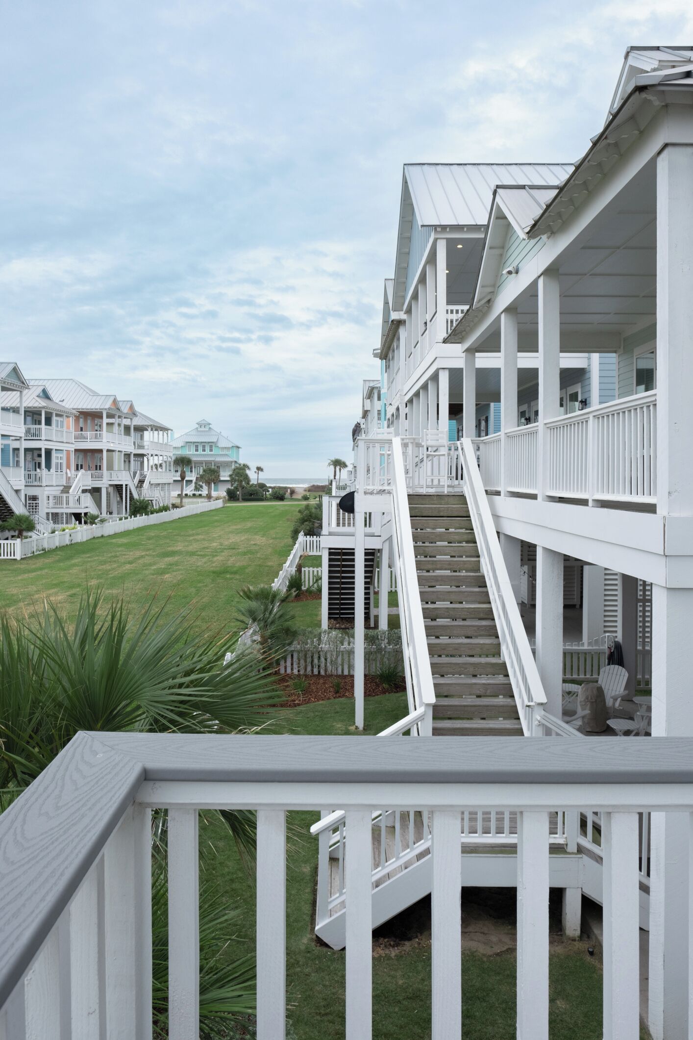 Un hotel frente al mar con varios balcones y una escalera que conduce a los pisos superiores.