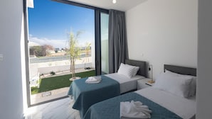 A hotel room with two beds, a large window with a view of the outdoors, and a modern design. - Villa Malin, Brand New, 5BDR Protaras Villa with Heated Pool (optional) (Protaras)
