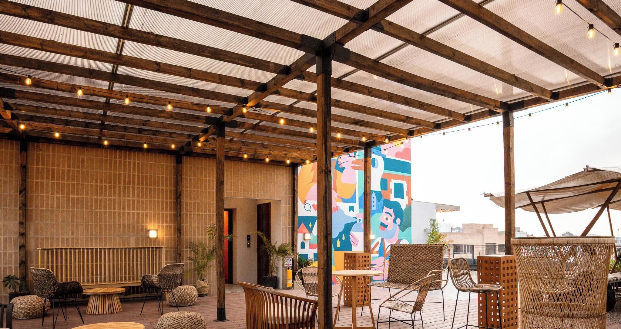 An outdoor seating area with wooden furniture and a covered roof.