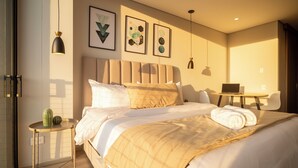 Una habitación de hotel moderna con una cama grande, una mesita de noche y un escritorio con una silla.
