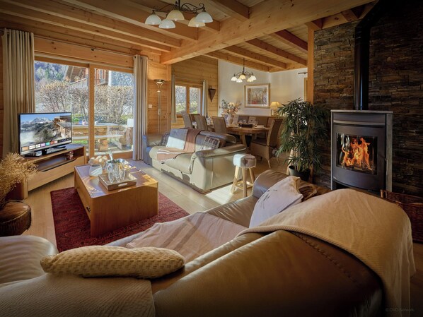 Una sala de estar acogedora con chimenea, televisor y comedor.