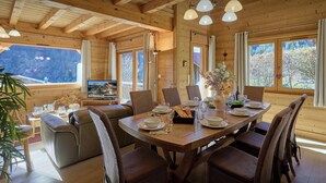 Ein Holzinterieur mit einem Esstisch, gedeckt für sechs Personen, umgeben von Korbstühlen.