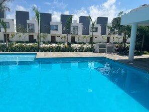 Una piscina con edificios modernos al fondo.