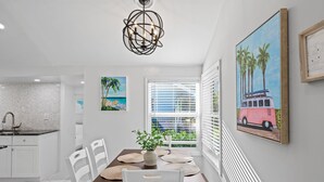 A dining area with a white table, chairs, and a decorative plant centerpiece. - Charming 2-bedroom house with WiFi and AC in welcoming Fort Lauderdale (Fort Lauderdale)