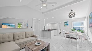A spacious living area with a sofa, coffee table, and dining table with chairs. - Charming 2-bedroom house with WiFi and AC in welcoming Fort Lauderdale (Fort Lauderdale)