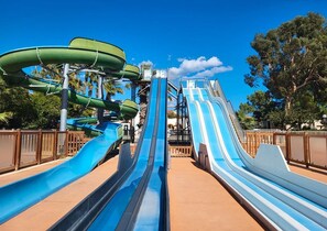 Um parque aquático com várias tobogãs e um céu azul límpido.