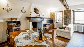 Ein gemütliches Wohnzimmer mit Kamin, Holzmöbeln, einem Fernseher und einem Fenster mit Blick.
