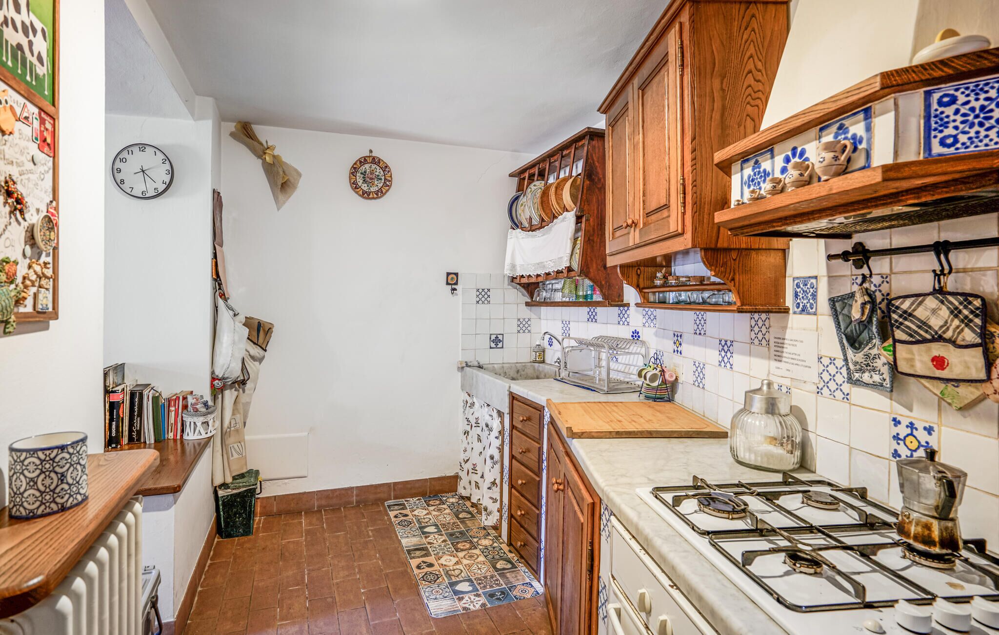 A kitchen with wooden cabinets, a gas stove, and a tiled backsplash.