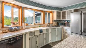 Una cucina moderna con piani in granito, elettrodomestici in acciaio inossidabile e mobili chiari.