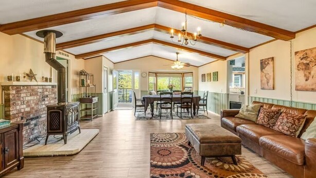 A spacious living room with a fireplace, a dining area, and a leather sofa. - Deer Harbor Cottages, Entire Property. Sleeps up to 16. 3 Hot Tubs. 4 Bedrooms. (Eastsound)