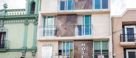 A hotel building with multiple floors, balconies, and a prominent 'HOTEL' sign.