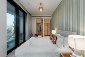 A modern hotel room with a large bed, a view of the city, a bathroom, and a cityscape visible through the window.