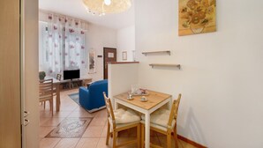 Un comedor con una mesa y sillas de madera, una televisión y un sofá azul.