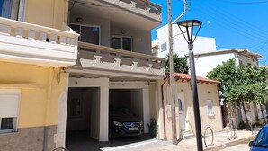 A multi-story building with balconies, a parking garage, and a street lamp. - Odysseas Nea Chora Apartment with Sea View, Wi-Fi and Air Conditioning (Chania)