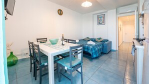 Un espacio habitable compacto con comedor, kitchenette y sofá.