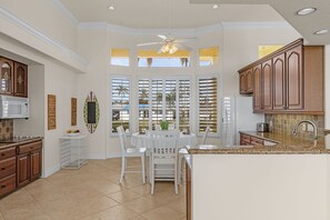 Enjoy cooking in this well-lit kitchen with a central island, sink, microwave, and range hood.