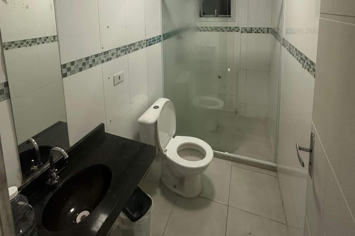Un baño con inodoro, lavamanos y zona de ducha.