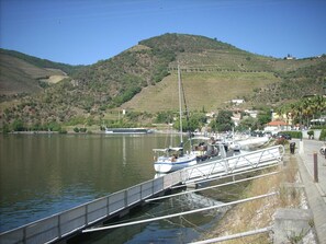 A riverside dock with boats, a bridge, and a hilly landscape in the background. - Casa da Jesus with Mountain View, Wi-Fi, and Air Conditioning (Provesende)