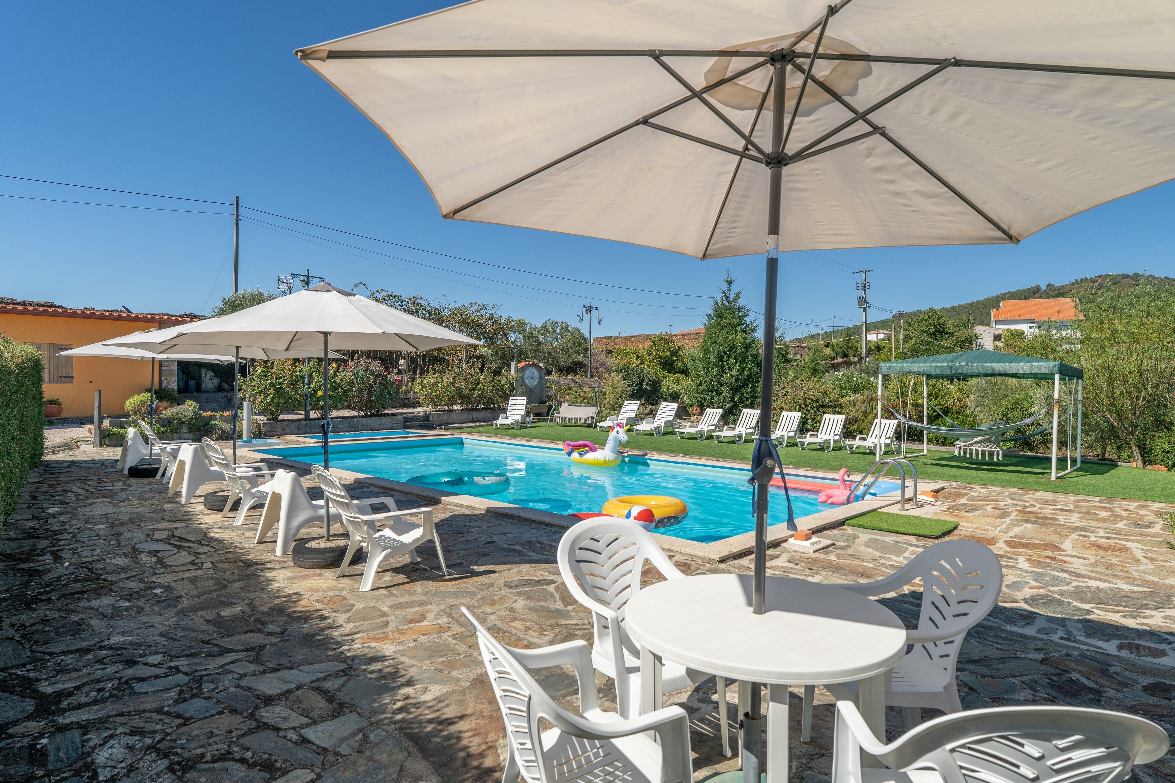 Ein Schwimmbecken mit Liegestühlen und Sonnenschirmen.