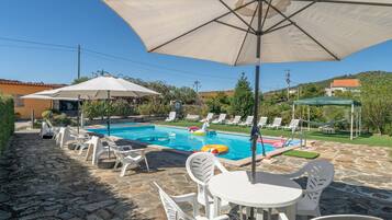 Ein Schwimmbecken mit Liegestühlen und Sonnenschirmen.