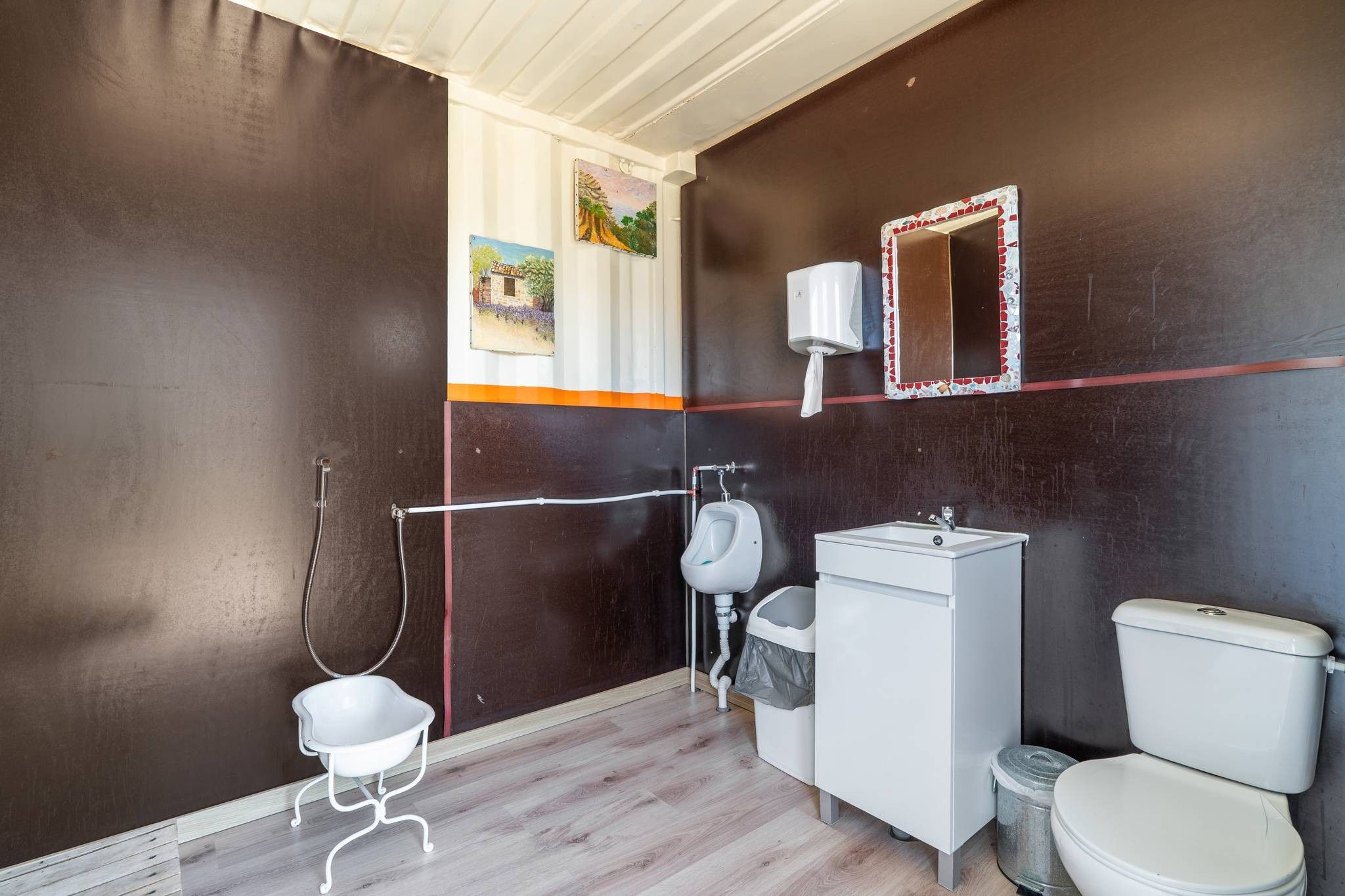 Een badkamer met toilet, bidet, wastafel en douche.