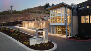A modern building with large windows, a stone entrance, and a sign that reads 'Apex.' - Ski-in/ Ski-out - Enjoy Luxury Amenities, Private Hot Tub! Walk to the Canyon Village Area (Park City)