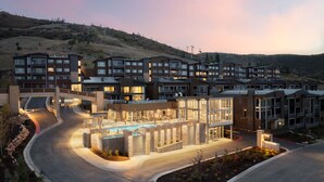 A modern hotel with multiple floors, a swimming pool, and a landscaped entrance. - Ski-in/ Ski-out - Enjoy Luxury Amenities, Private Hot Tub! Walk to the Canyon Village Area (Park City)