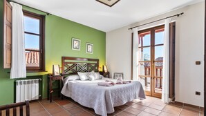 Une chambre à coucher avec un lit, une table de chevet, une chaise, une fenêtre et une porte.