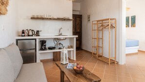 A compact living space with a kitchenette, a dining area, and a small seating area.
