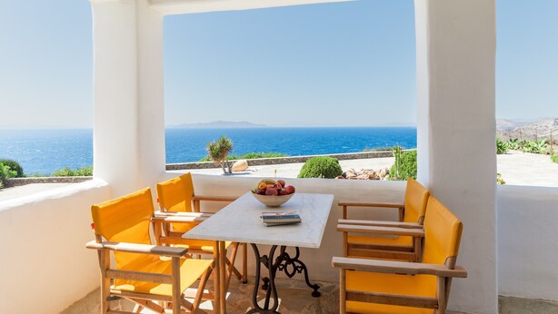 Ein Balkon mit Tisch, Stühlen und einer Obstschale.