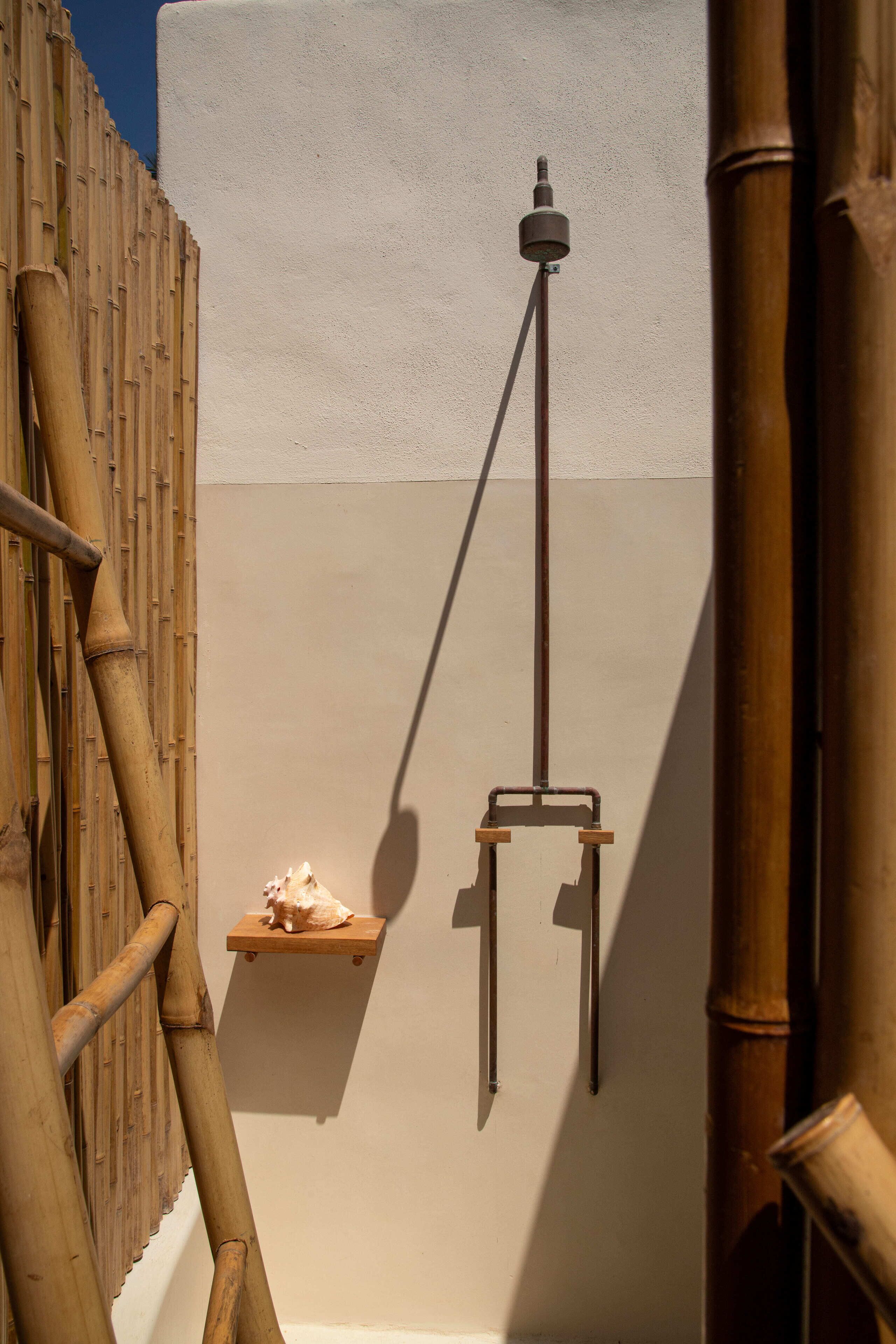 A wall-mounted light fixture with a bamboo structure and a small shelf.