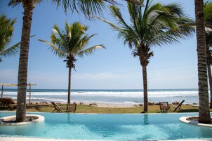 Una piscina al aire libre, sombrillas, tumbonas